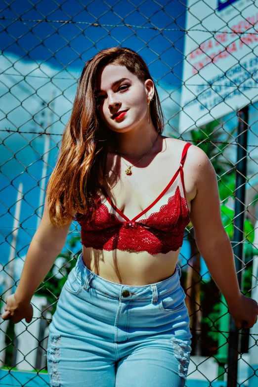 the young woman is posing for the camera in jeans and red 