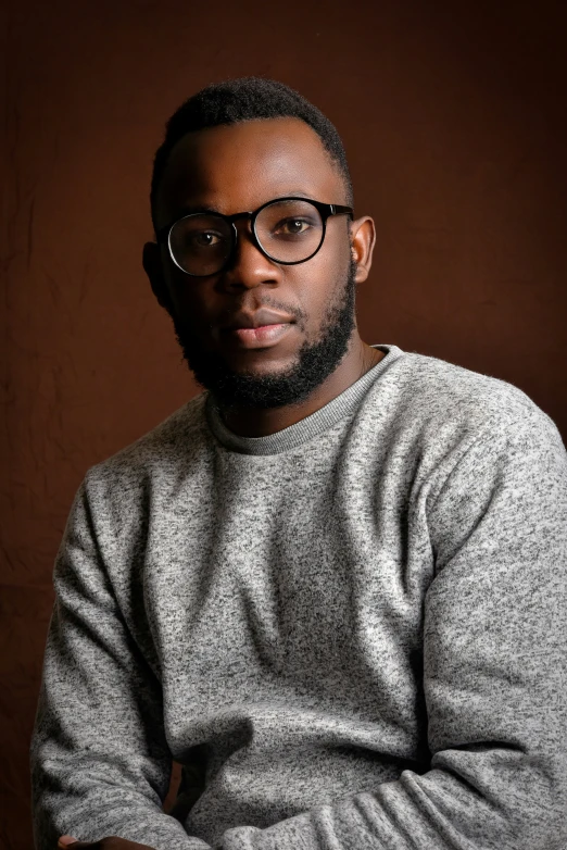 a man with glasses posing for a po