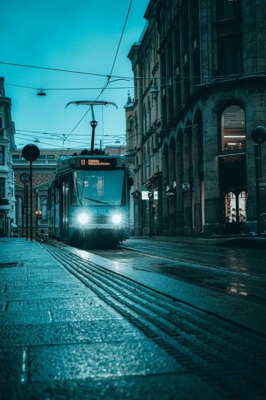 a passenger train makes its way down the city street at night