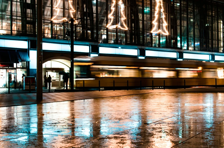 a subway at night near a large lighted building