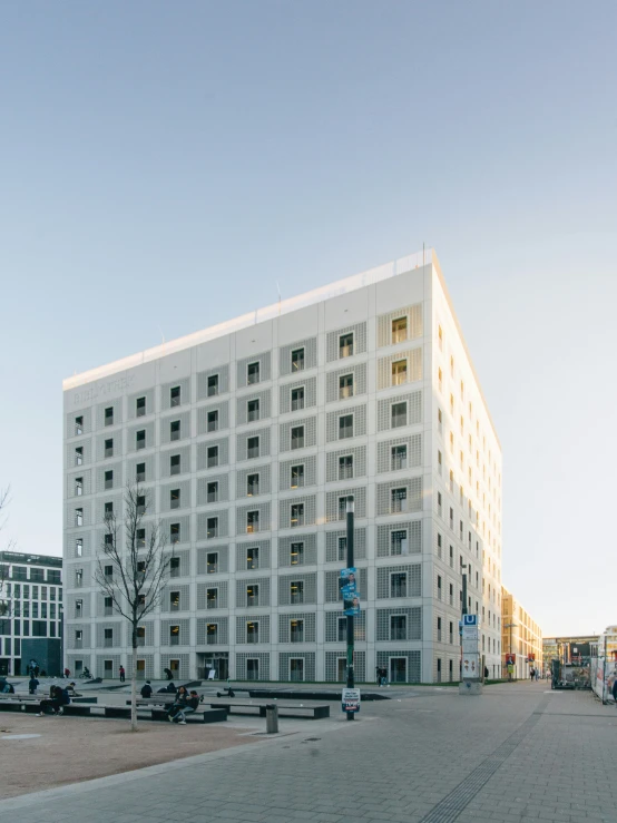 several buildings in a large city square with few cars parked