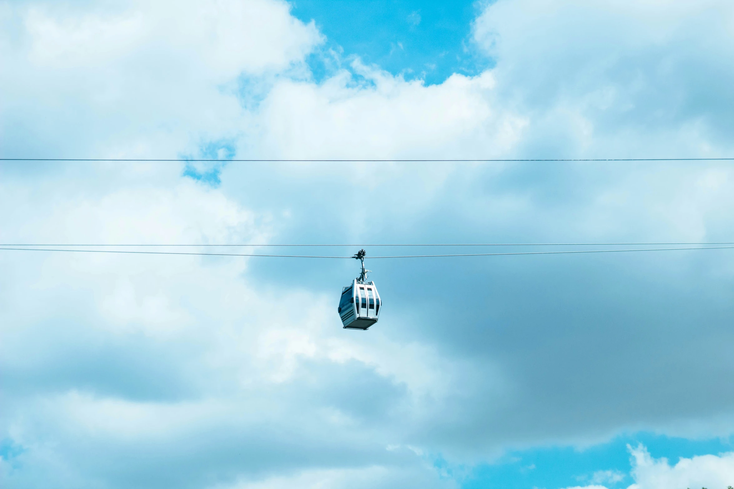 two electrical wires in the foreground and the sky in the background