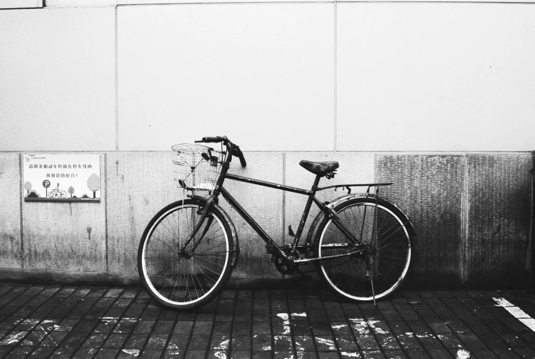 a bike leans against a wall in a black and white po