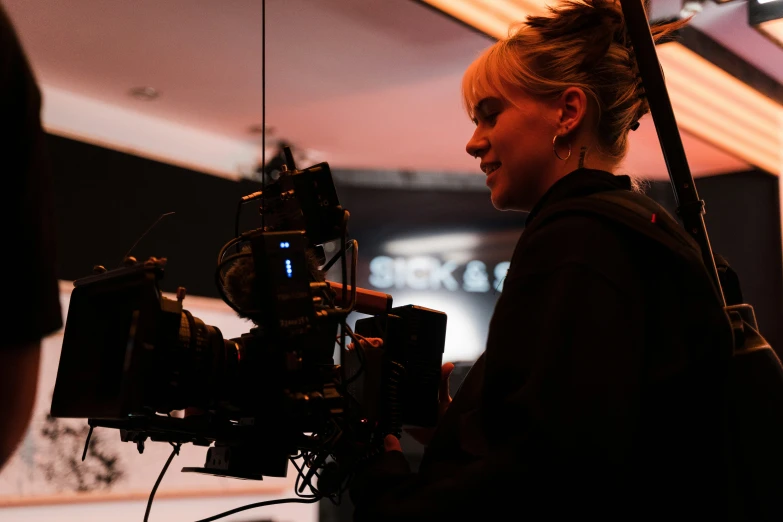 a woman holding a video camera while standing in front of a building