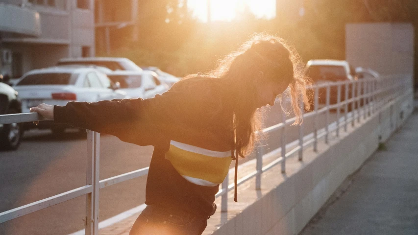 a woman with a skateboard leans on the railing