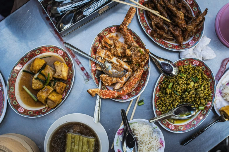 a table topped with plates and bowls full of food