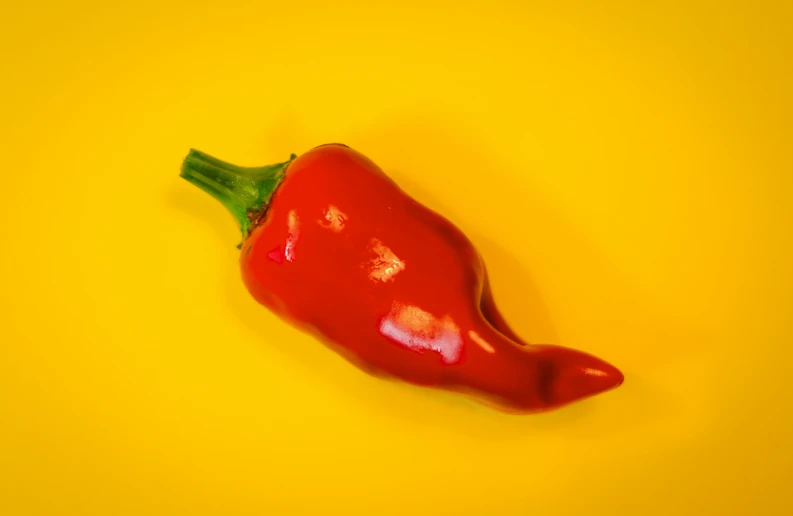 an red chili peppers on a yellow surface