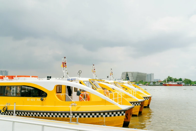 three yellow and white ferry boats in the water