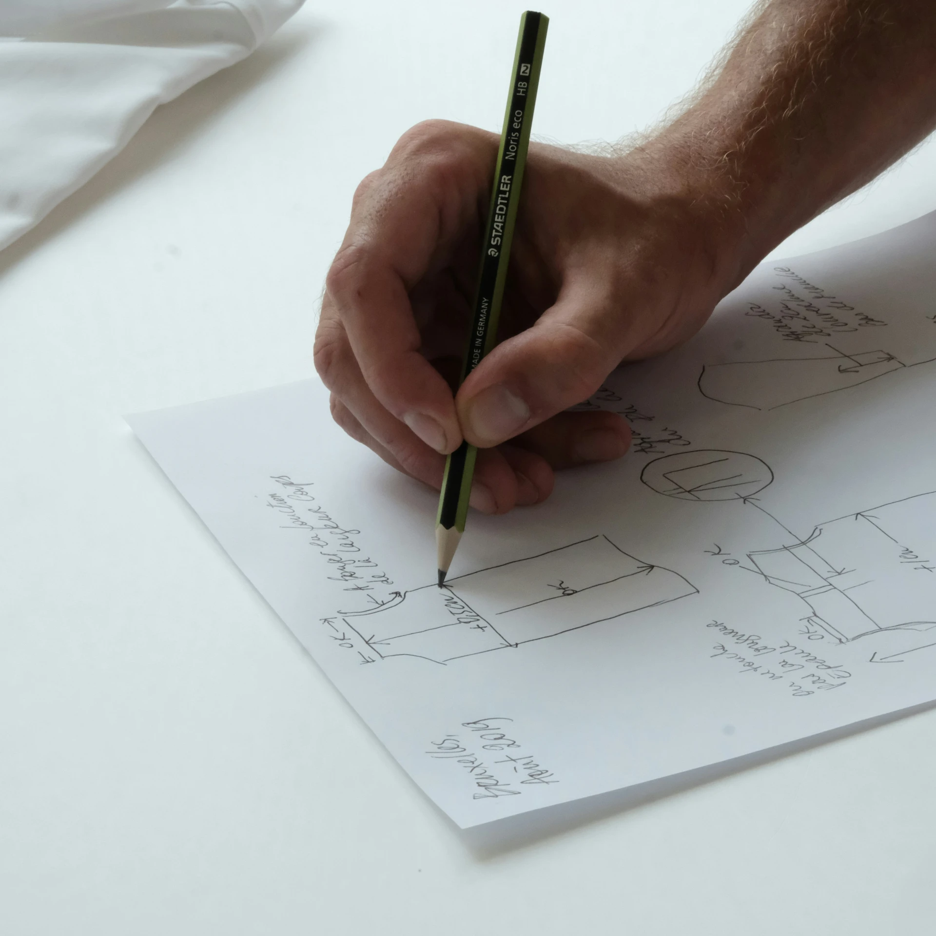 a hand holding a pencil while writing on a paper