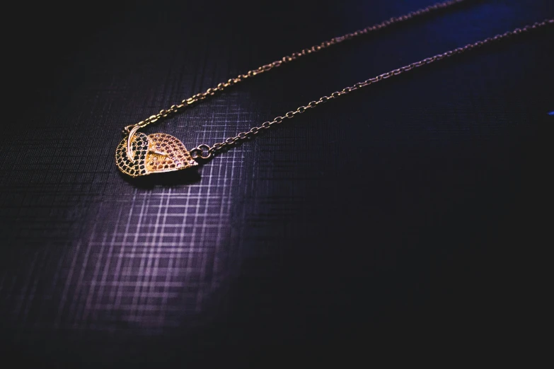 a small diamond heart hangs from a necklace