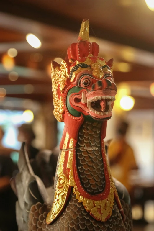 a chinese statue of a rooster with a bird like face