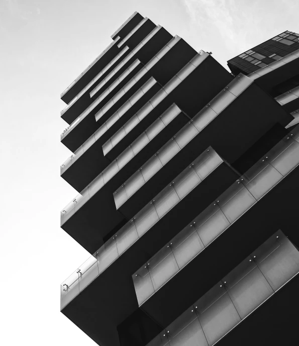 a tall black and white building on the ocean