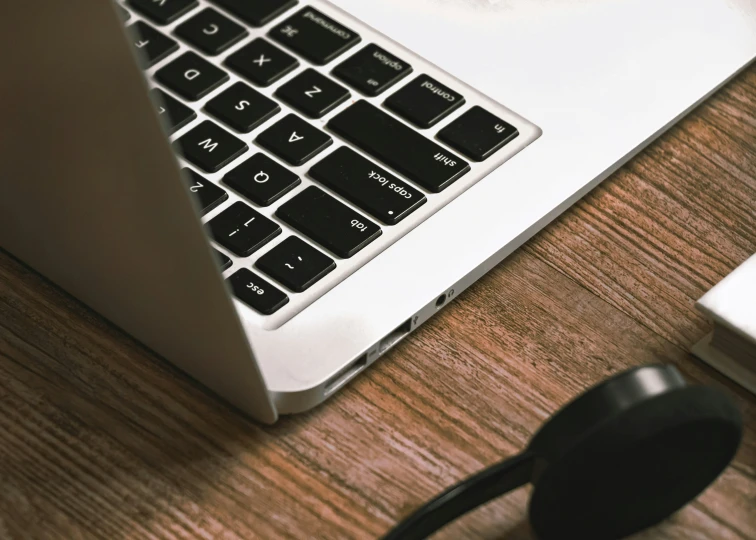 a computer with a pair of headphones beside it