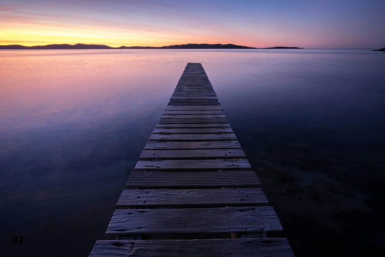 the dock leading to the water during sunrise