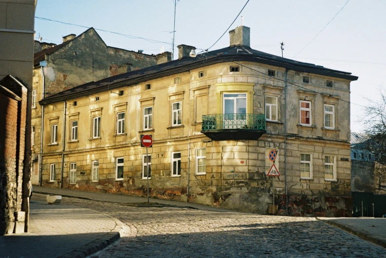 an old building with a balcony in front of a stone paved road