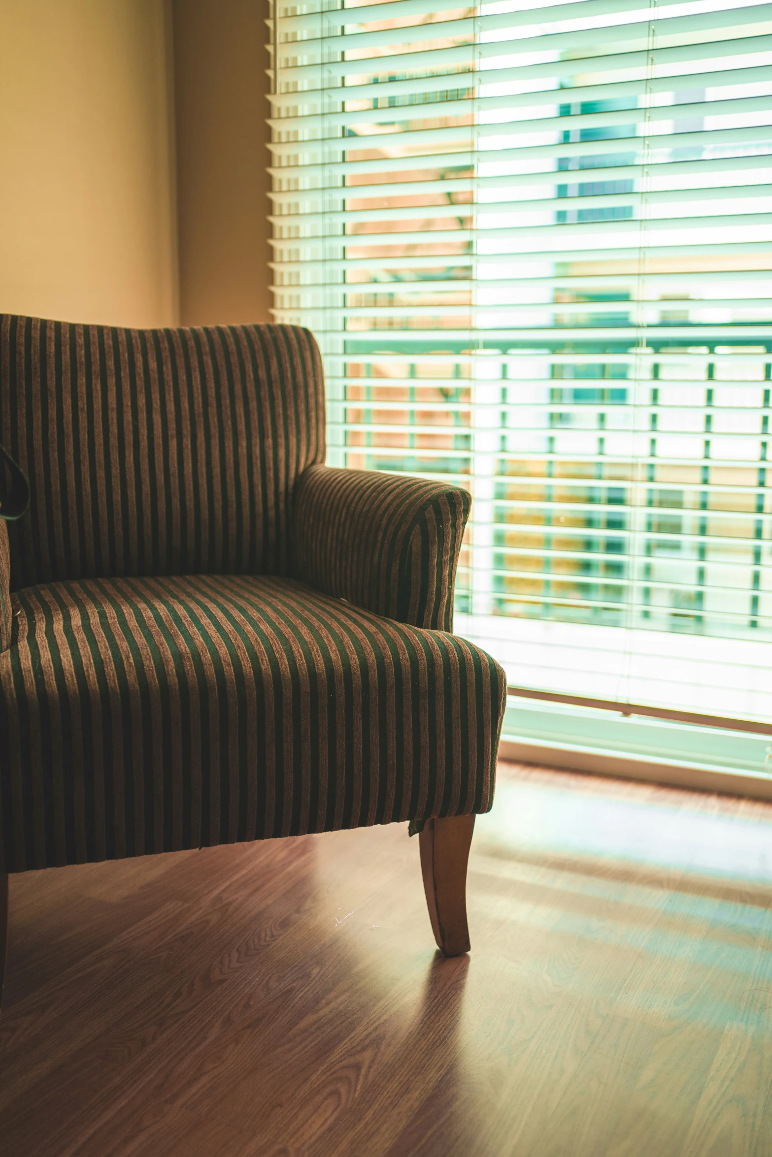 a striped couch sitting by a window in the corner of a room