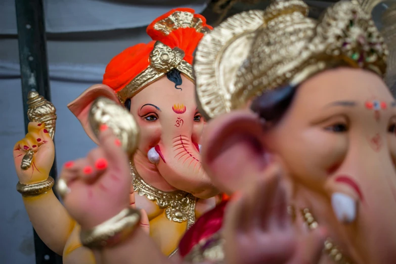 a row of statues of elephants wearing colorful jewelry