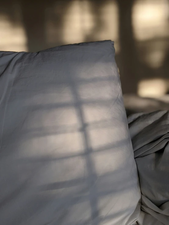 a bed with an open pillow and the pillows slightly covered by the covers