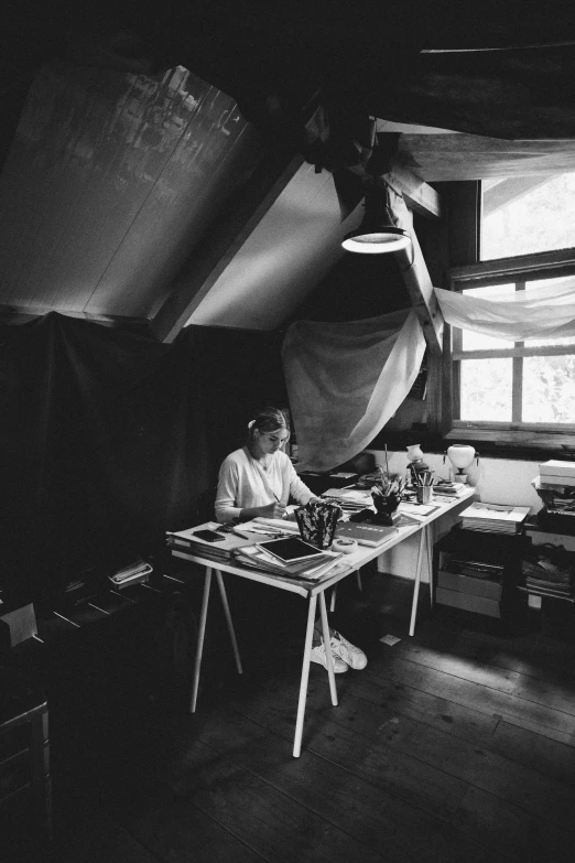 black and white pograph of woman sitting in an old tent
