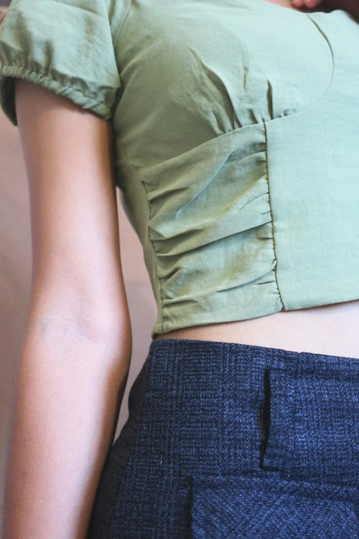 a woman's bottom showing as she wears a green crop top
