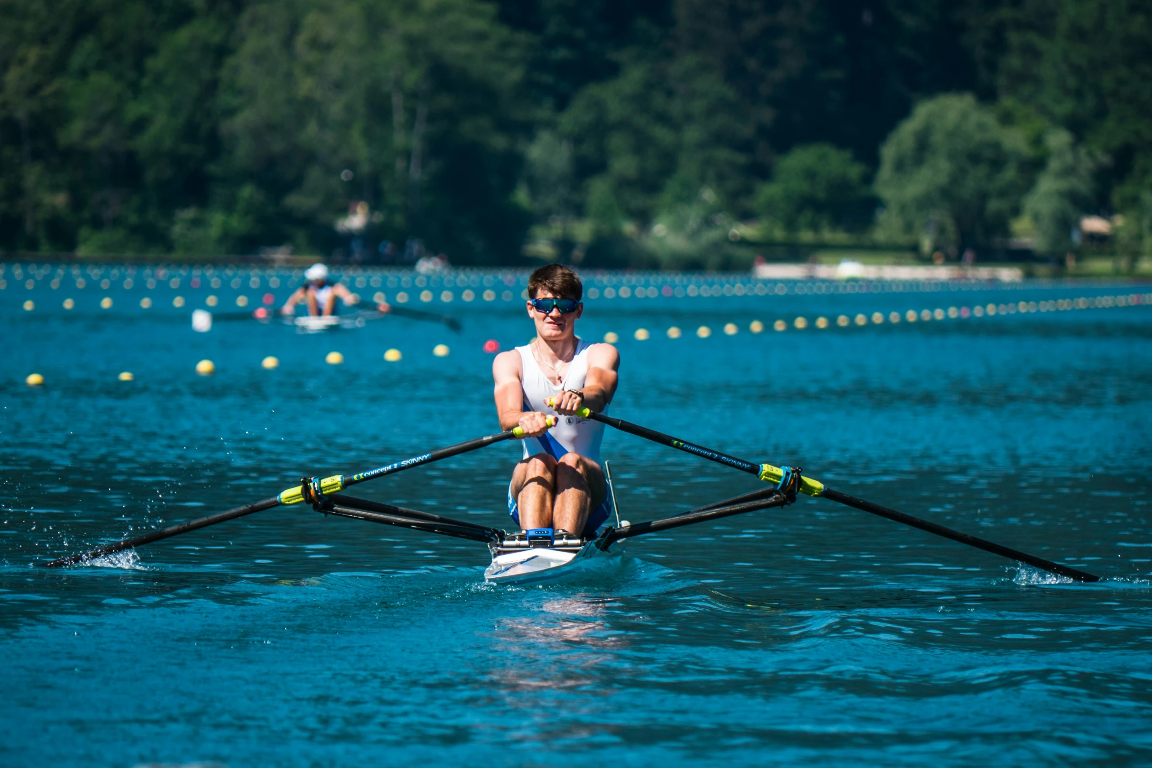 a rower sitting on a paddle boat in the middle of a lake