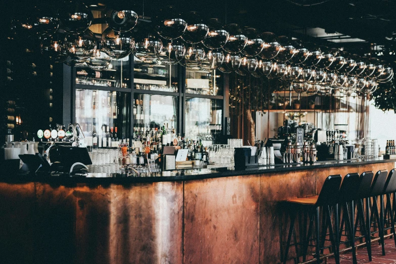 the bar has all wooden bars that have light bulbs above