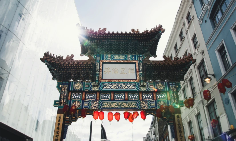 a chinese clock with hanging decorations on it in the middle of a street