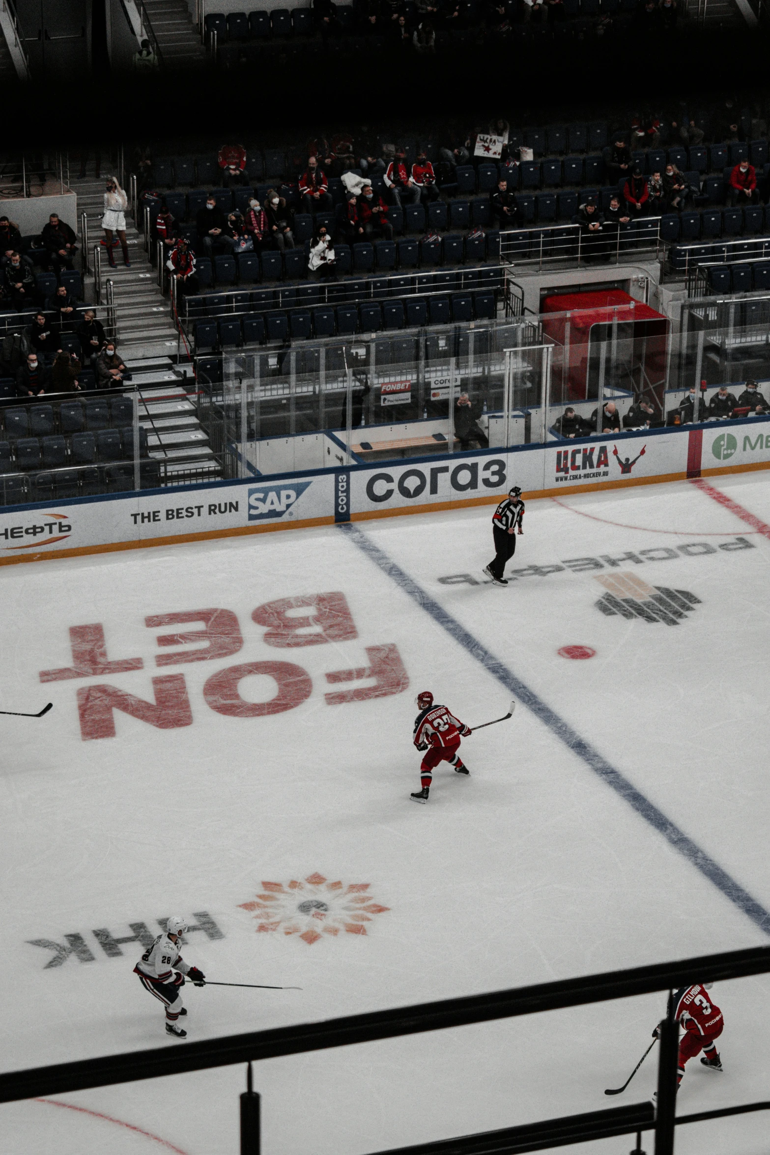 hockey on an ice rink in a stadium with spectators