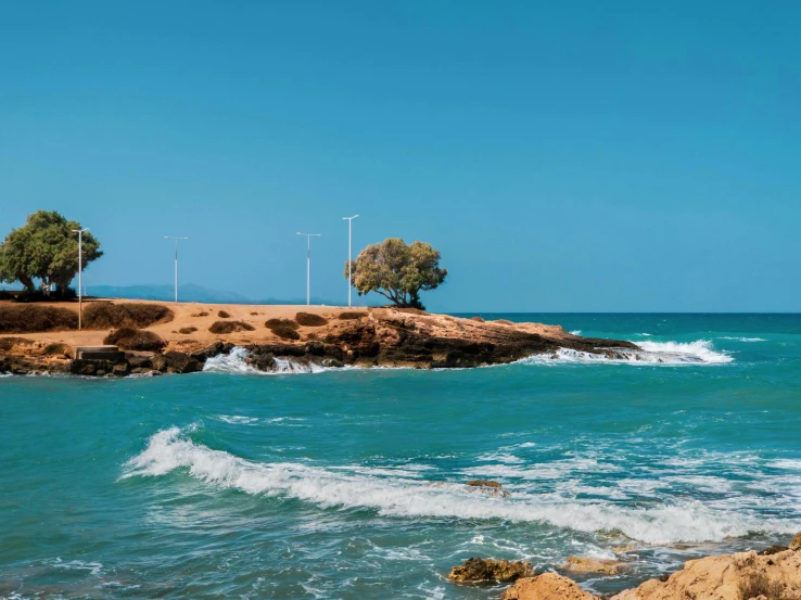 a beautiful ocean scene with small trees near the shore