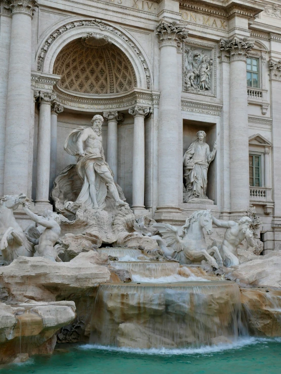 an outdoor fountain and building is surrounded by a water feature