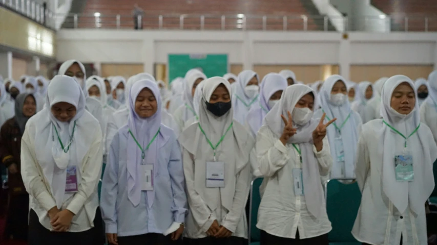 some women with white head coverings and one has a peace sign