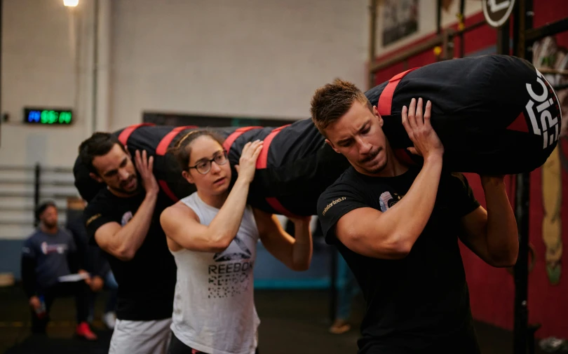 an athlete lifting another on a mat while being lifted