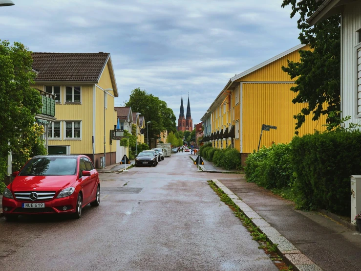 red cars are parked along the side of a city street