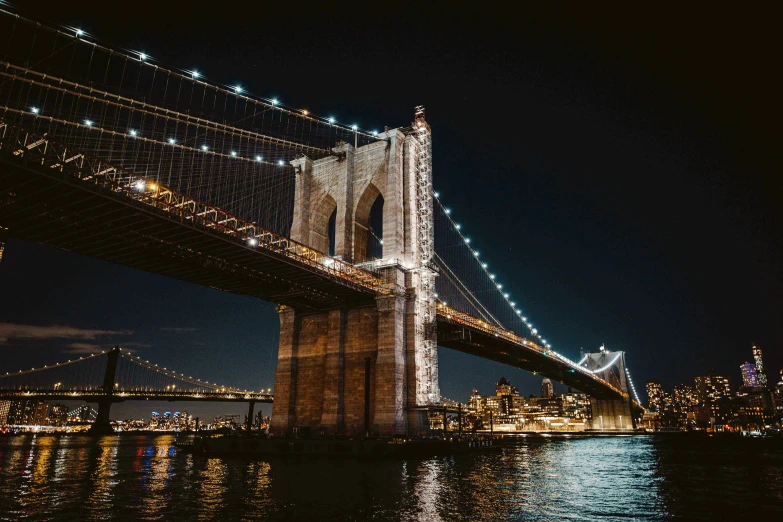 a long bridge over the water at night