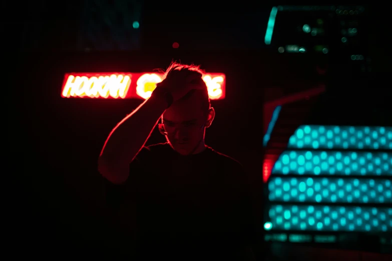 man with headphones stands in dark lit area