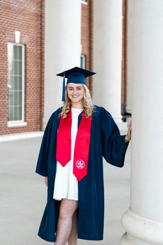 female graduate in graduation cap, gown and red stole