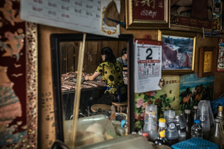 a  checks her sewing machine from a mirror