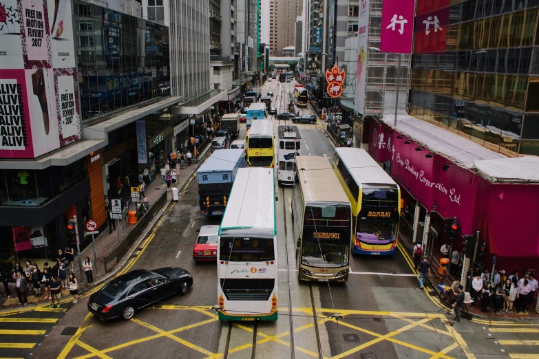 a busy street with many buses moving on the road