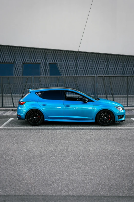 a light blue car sits in a parking lot