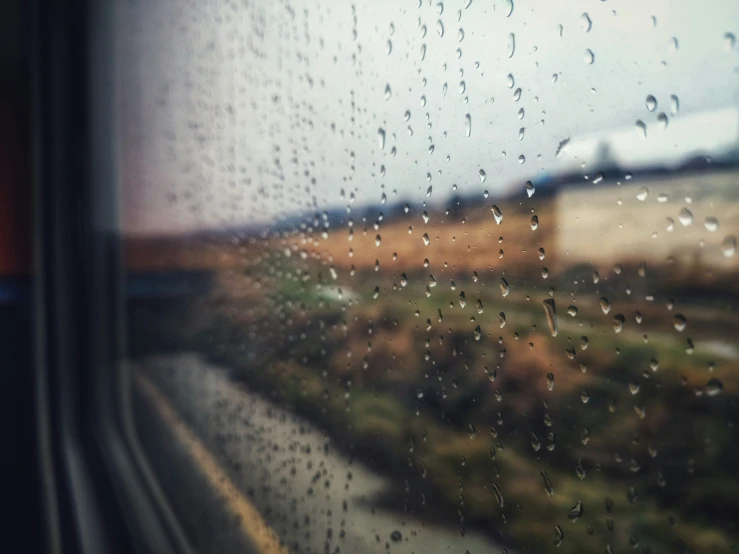 rain drops are falling on the window of a train