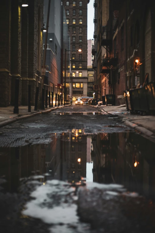 a street is reflecting the buildings at night