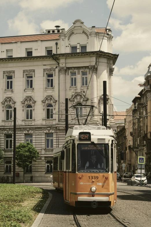 the tram car travels in front of an old building