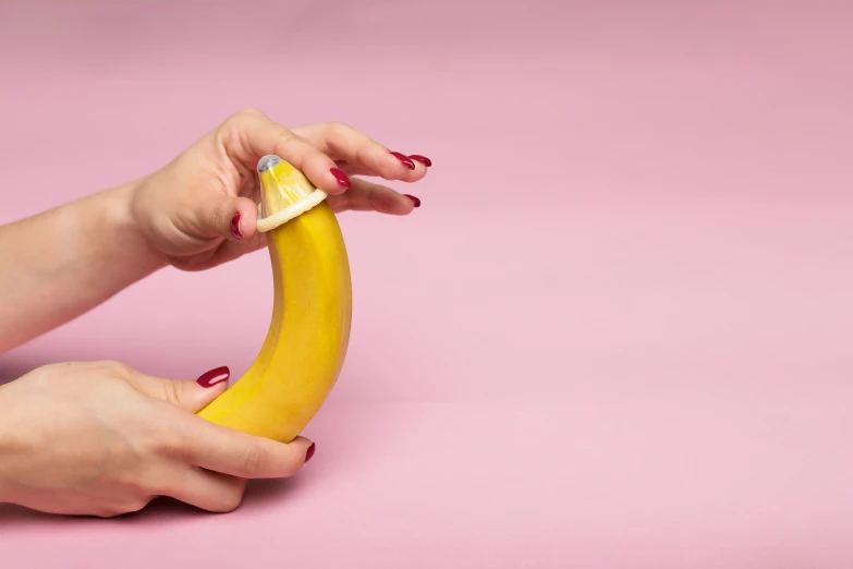 woman's hand is holding a banana and a bite taken out