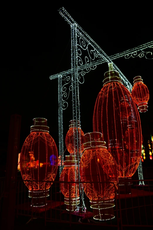 large red lanterns hanging on an intricate wire fence