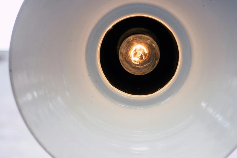 a white round light sitting inside of a white light bulb