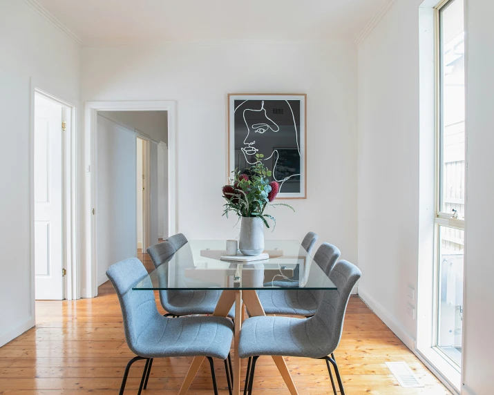 a dining room with a glass table and four chairs