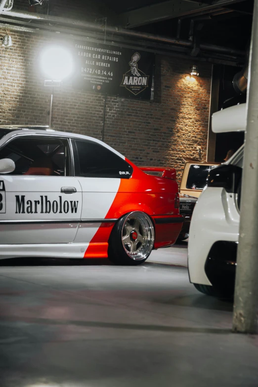 a car that is painted orange and white in an underground parking garage