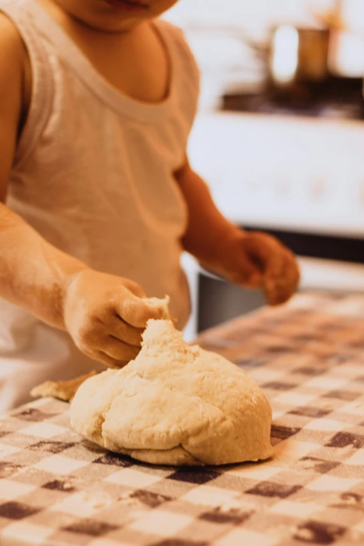 a man is preparing some pizza dough for his child