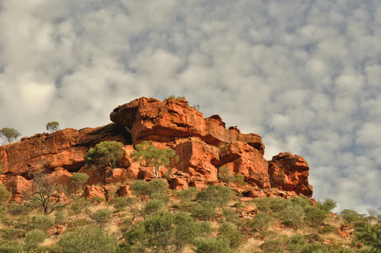 some rocky mountain formations with trees and clouds