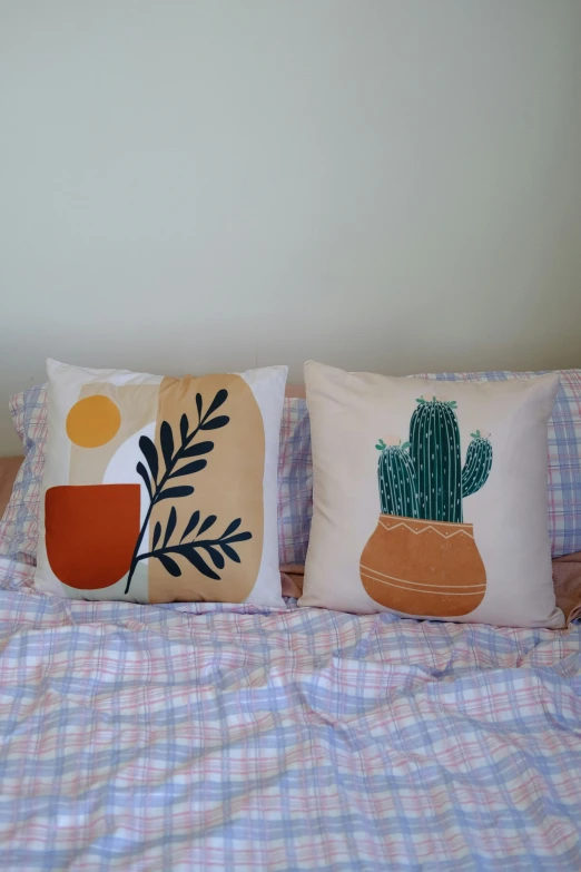 two decorative pillows in different colors on a bed